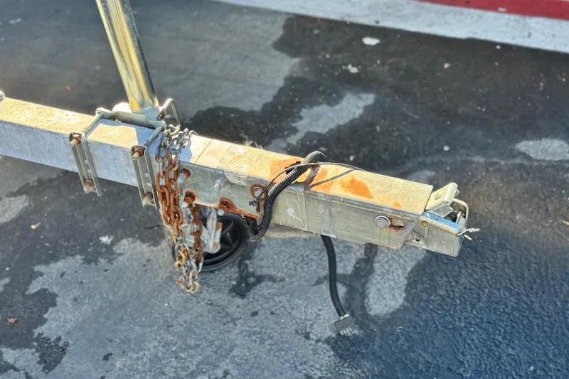 Slide: The Image of Trailer hitch of a 2021 Clearwater 2000 C/C with rusted chains on asphalt. - 30