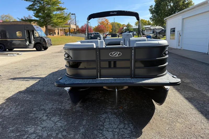 Slide: The Image of 2026 Bentley Pontoons Legacy 243 Swingback on pavement, with delivery truck in background. - 7