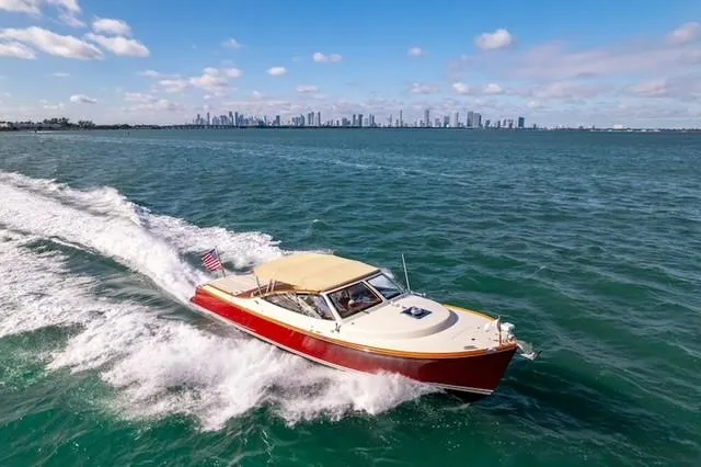Slide: The Image of 2009 Hinckley Runabout 38 cruising on open water with city skyline in background. - 2
