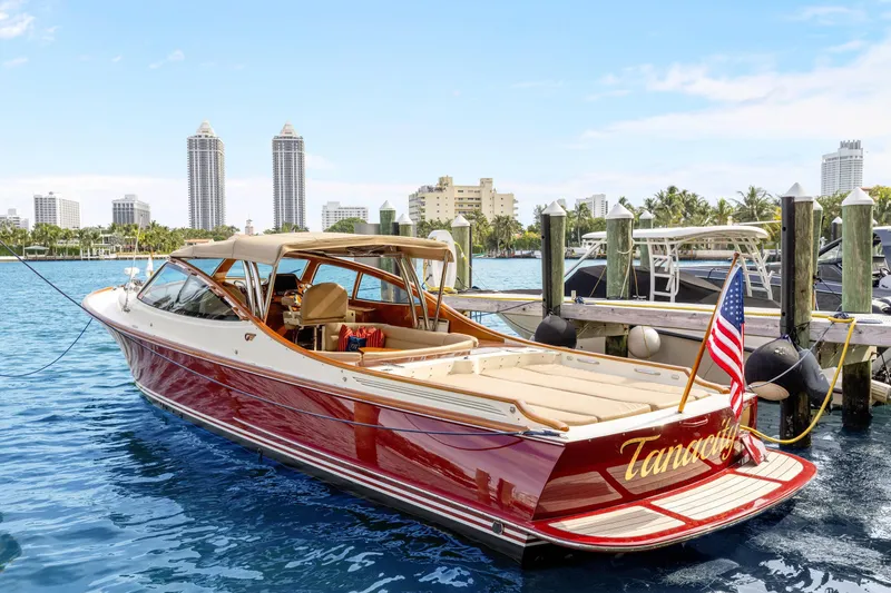 Slide: The Image of 2009 Hinckley Runabout 38 docked in a marina, featuring elegant design and American flag. - 4