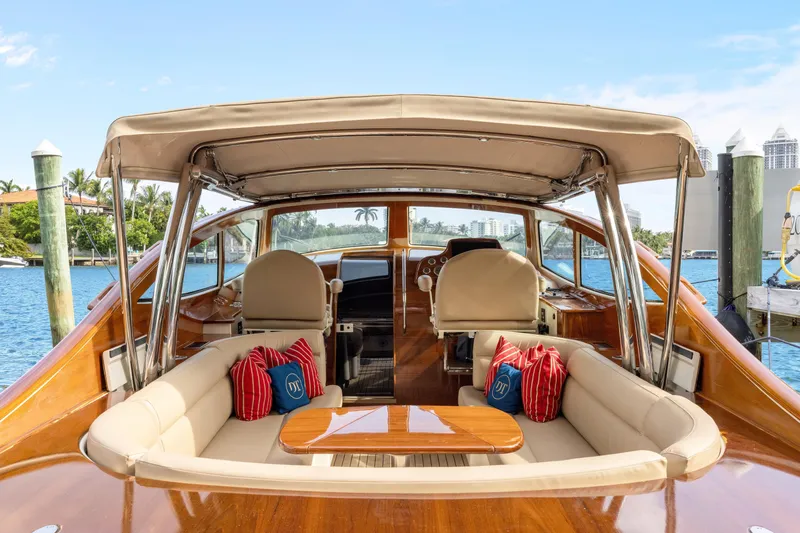 Slide: The Image of 2009 Hinckley Runabout 38 yacht with elegant seating and canopy, docked by the water. - 8