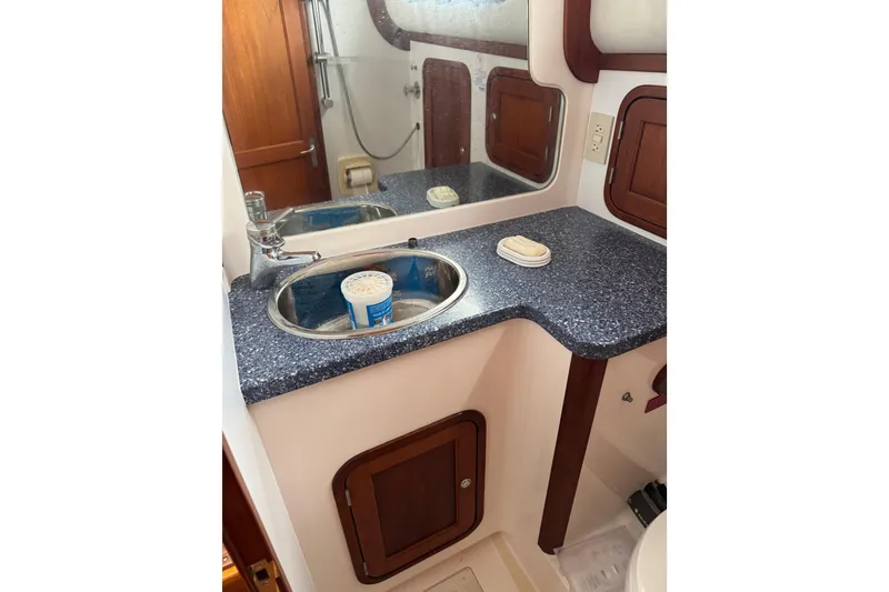 Slide: The Image of Bathroom sink area in 2001 Legacy Yachts Express, featuring countertop and mirror. - 52