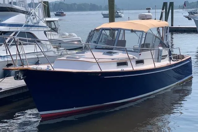 Slide: The Image of 2001 Legacy Yachts Express boat docked in marina, featuring blue hull and tan canopy. - 94