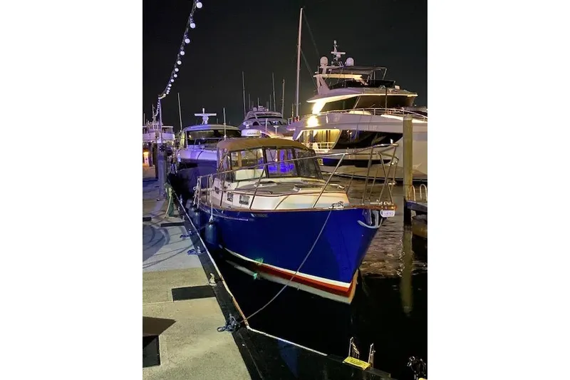 Slide: The Image of 2001 Legacy Yachts Express docked at night, illuminated by string lights. - 98