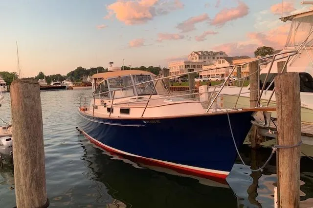 Slide: The Image of 2001 Legacy Yachts Express docked at sunset, featuring a sleek blue hull. - 99