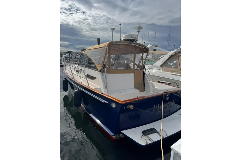 The Image of 2001 Legacy Soft Top boat docked at marina under cloudy sky. - 0