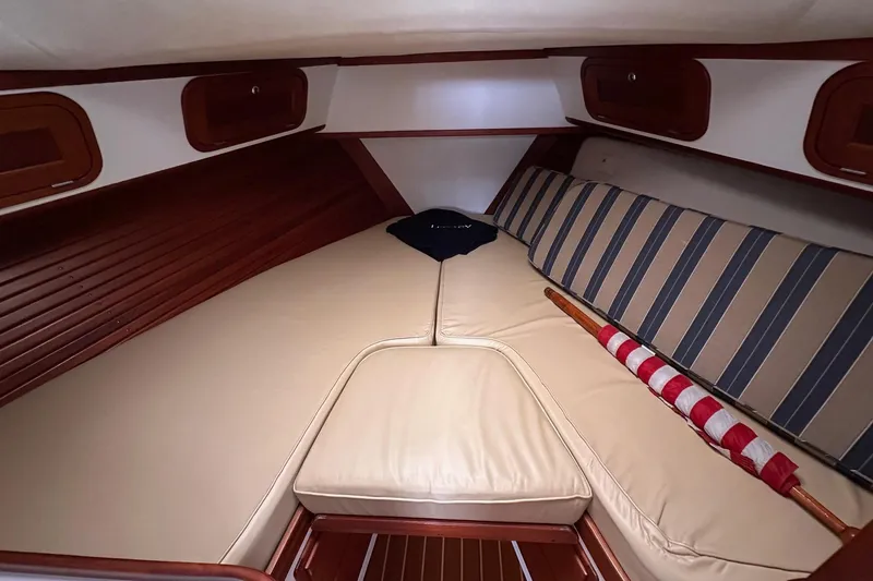 Slide: The Image of 2001 Legacy Yachts Express cabin interior with beige cushions and striped pillows. - 109