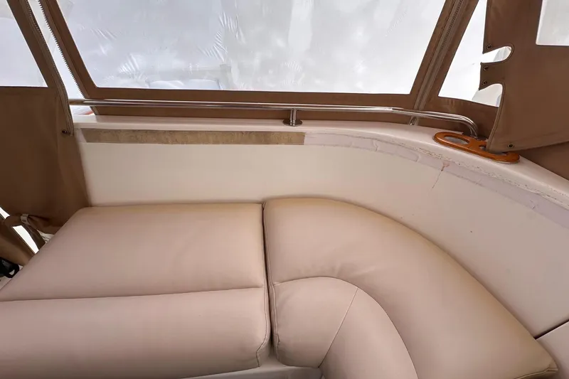 Slide: The Image of Beige seating area on 2001 Legacy Yachts Express, featuring cushioned upholstery and window views. - 110