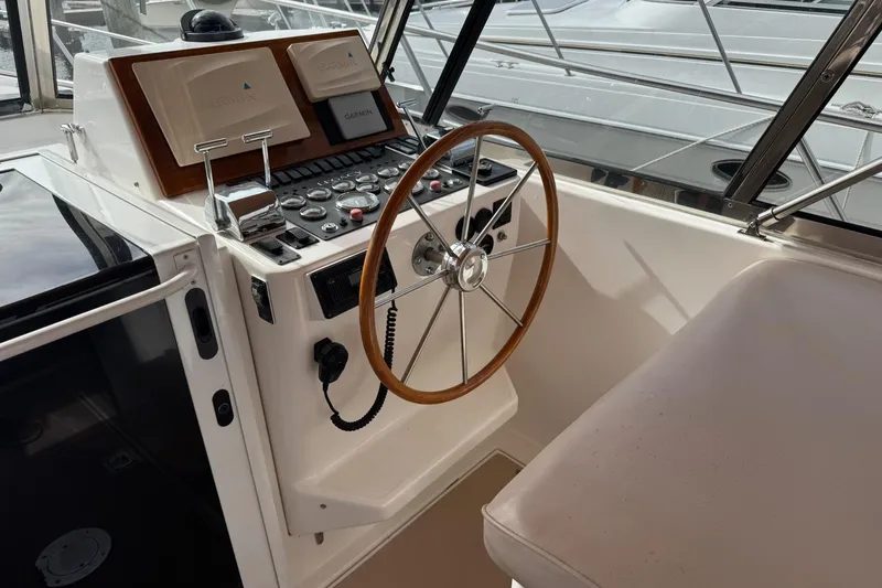Slide: The Image of 2001 Legacy Soft Top boat helm with wooden steering wheel and navigation controls. - 16