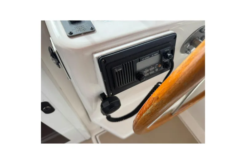 Slide: The Image of 2001 Legacy Soft Top boat dashboard with radio and wooden steering wheel. - 21