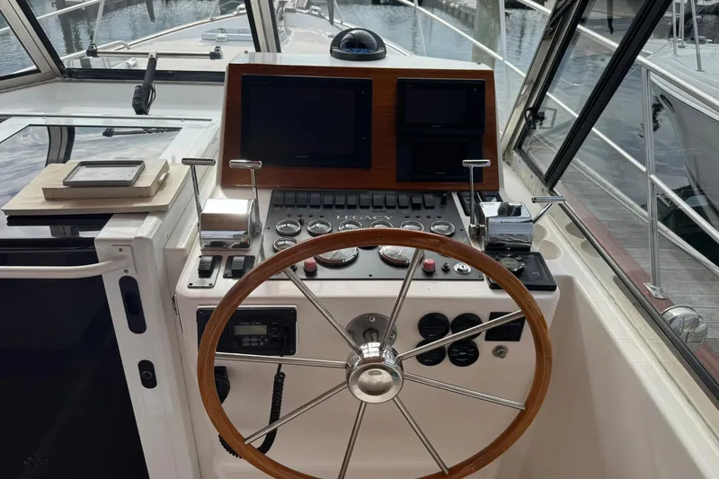 Slide: The Image of 2001 Legacy Soft Top boat helm with wooden steering wheel and navigation controls. - 24