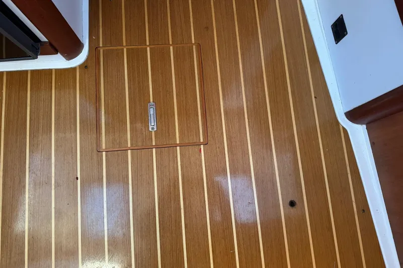 Slide: The Image of Teak wood flooring with hatch on 2001 Legacy Soft Top boat interior. - 37