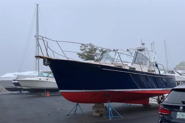 Slide: The Image of 2001 Legacy Soft Top boat on stands in a marina, with overcast sky. - 45