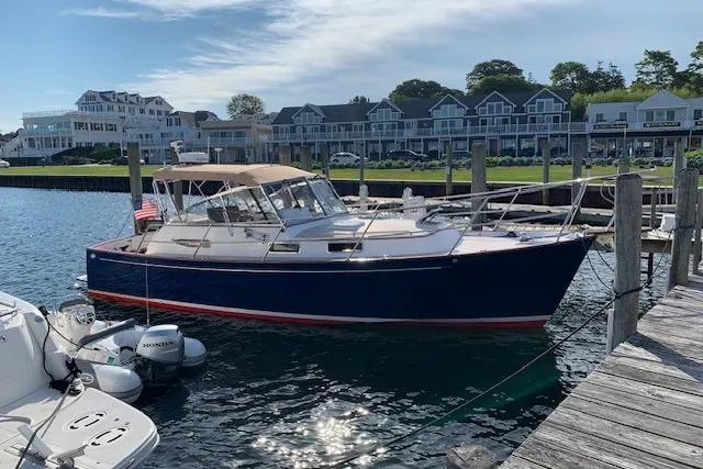 Slide: The Image of 2001 Legacy Soft Top boat docked at marina with waterfront buildings in background. - 48