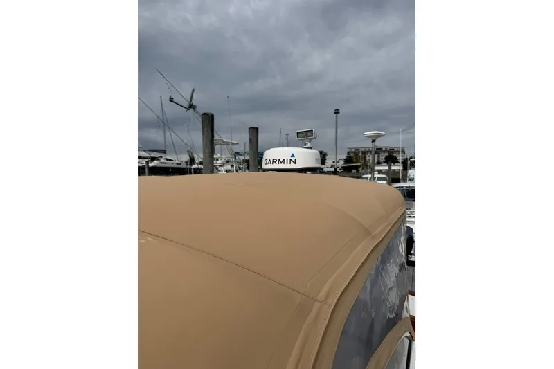 Slide: The Image of 2001 Legacy Soft Top boat with Garmin equipment under cloudy sky at marina. - 8