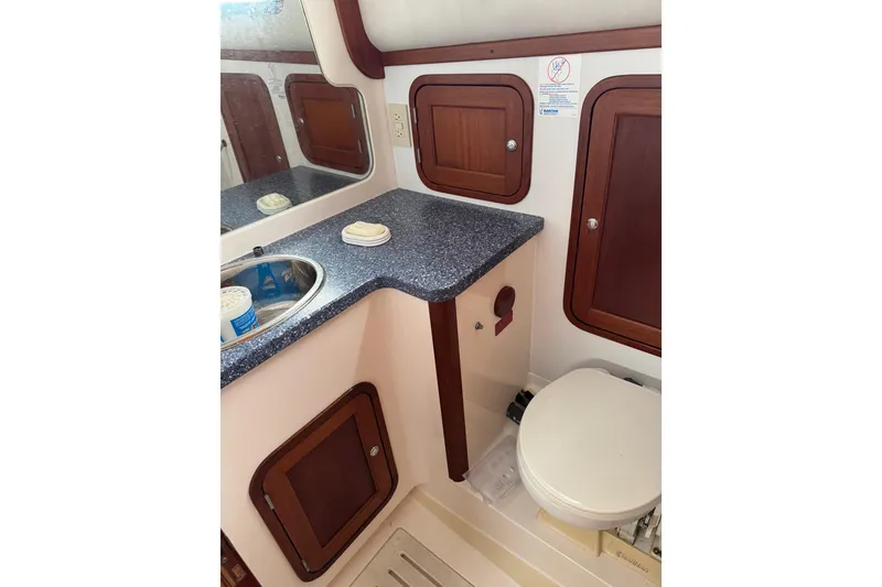 Slide: The Image of 2001 Legacy Yachts Express bathroom with sink, countertop, and wooden cabinets. - 81