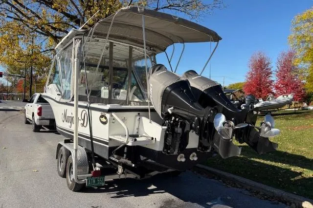 Slide: The Image of 2001 Dusky 252 CSS boat on trailer with dual outboard motors. - 4