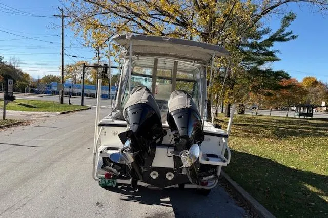 Slide: The Image of 2001 Dusky 252 CSS boat with dual outboard motors on a sunny street. - 5