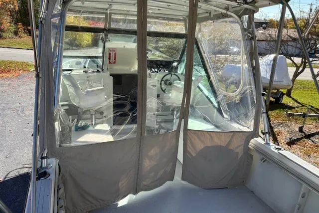 Slide: The Image of 2001 Dusky 252 CSS boat interior with clear enclosure and steering wheel. - 6
