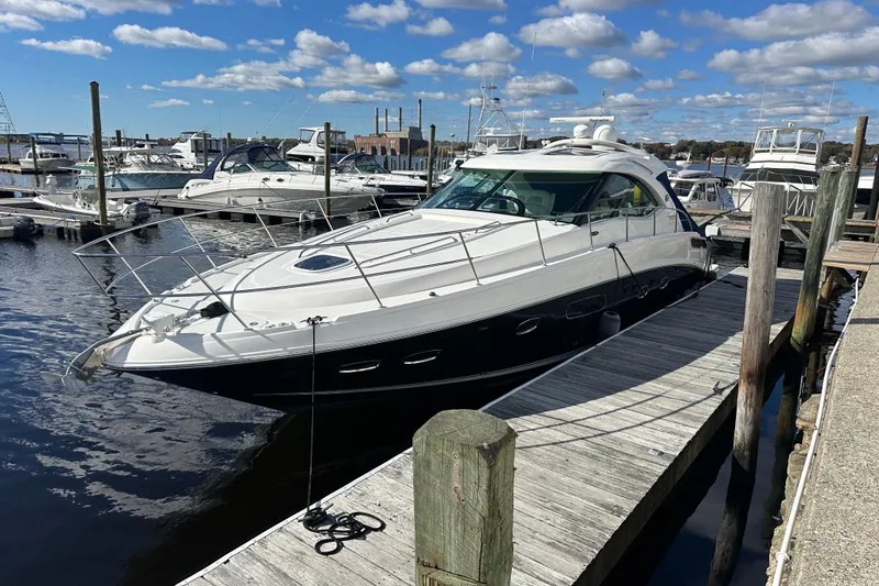 Slide: The Image of 2011 Sea Ray 470 Sundancer yacht docked at marina under blue sky. - 2