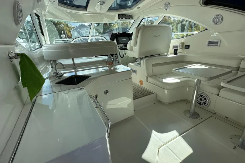 Slide: The Image of Interior of 2011 Sea Ray 470 Sundancer yacht with seating, table, and kitchenette. - 5
