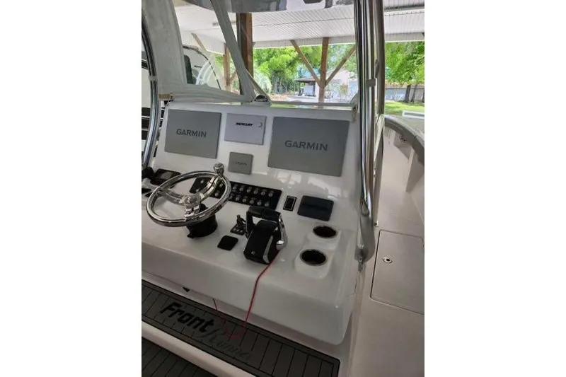 Slide: The Image of 2023 Front Runner 36 cc boat dashboard with Garmin navigation displays. - 13