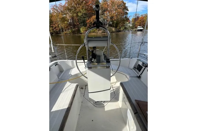 Slide: The Image of 1997 Beneteau Oceanis 321 sailboat cockpit with steering wheel, on a calm river. - 10
