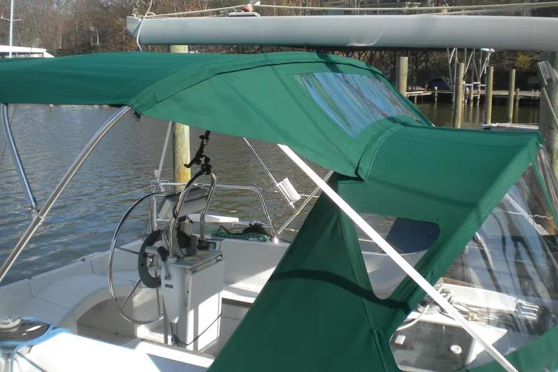 Slide: The Image of Green canopy on a 1997 Beneteau Oceanis 321 sailboat, docked by the water. - 11