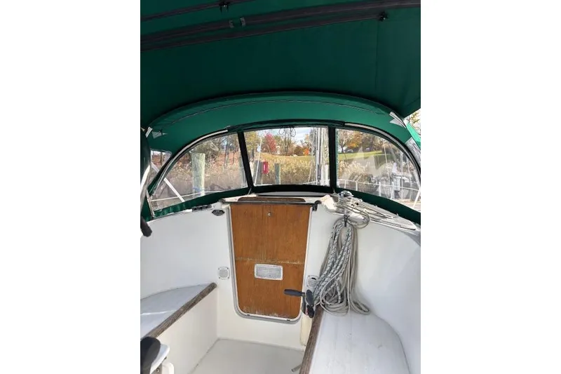 Slide: The Image of 1997 Beneteau Oceanis 321 cockpit with green canopy and wooden door. - 12