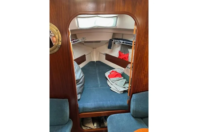 Slide: The Image of Cozy cabin interior of 1997 Beneteau Oceanis 321 sailboat with blue cushions and wooden finish. - 18