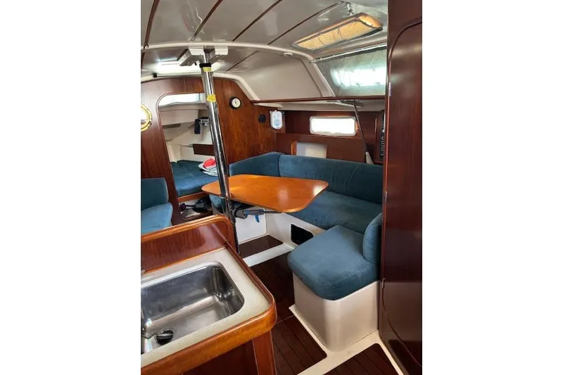 Slide: The Image of Interior of 1997 Beneteau Oceanis 321 sailboat with cozy seating and wooden finishes. - 19