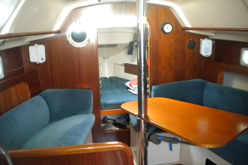 Slide: The Image of Interior of 1997 Beneteau Oceanis 321 sailboat with cozy seating and wooden table. - 26