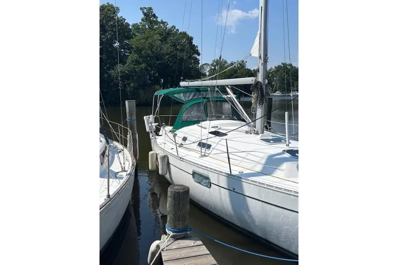 Slide: The Image of 1997 Beneteau Oceanis 321 sailboat docked by a serene waterfront. - 3