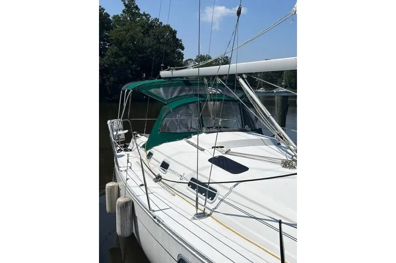 Slide: The Image of 1997 Beneteau Oceanis 321 sailboat docked, featuring green canopy and white deck. - 6