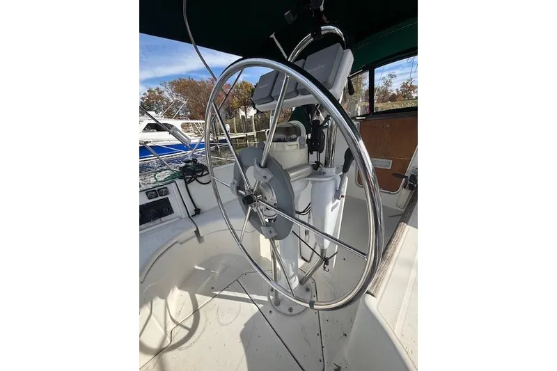 Slide: The Image of Steering wheel of a 1997 Beneteau Oceanis 321 sailboat in a marina setting. - 8