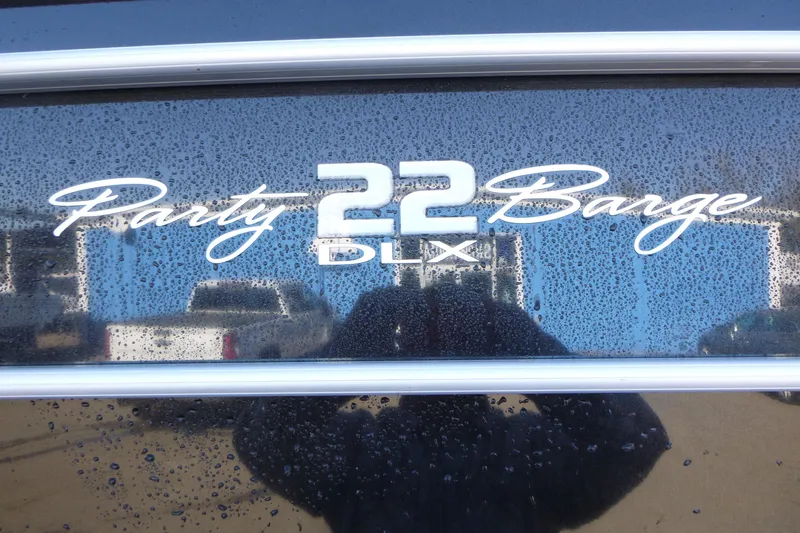 Slide: The Image of 2022 Sun Tracker Party Barge 22 DLX logo with water droplets on surface. - 13