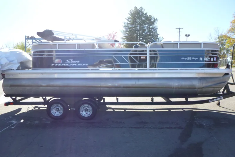 Slide: The Image of 2022 Sun Tracker Party Barge 22 DLX pontoon boat on trailer, parked outdoors. - 4