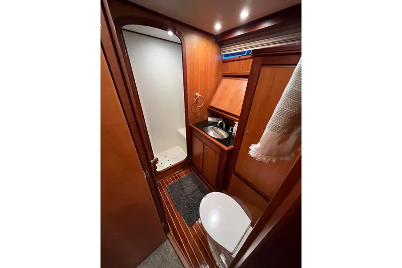 Slide: The Image of 2010 Mikelson 43 Sportfisher bathroom with shower, sink, and toilet in wooden interior. - 16