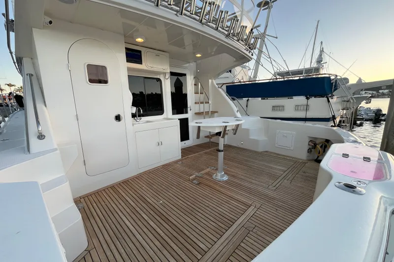 Slide: The Image of 2010 Mikelson 43 Sportfisher yacht deck with wood flooring and fishing equipment. - 35