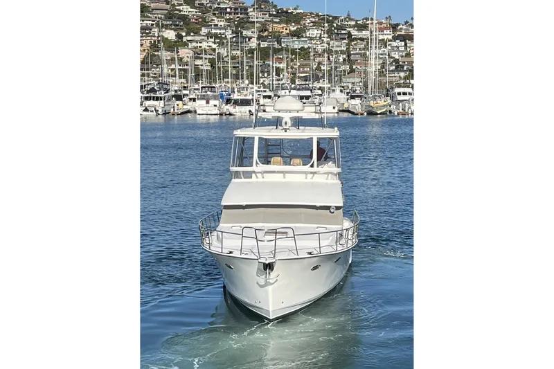 Slide: The Image of Mikelson 43 Sportfisher 2010 yacht in marina, surrounded by boats and hillside homes. - 4