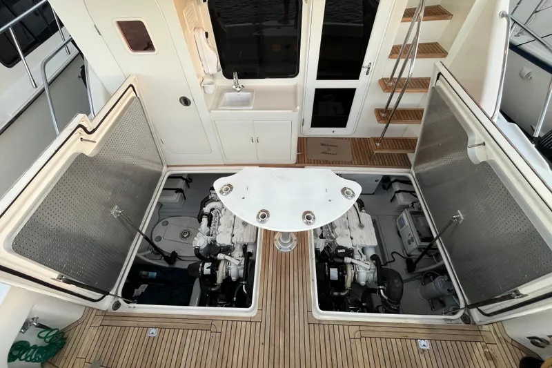 Slide: The Image of 2010 Mikelson 43 Sportfisher yacht engine room with open hatches and wooden deck. - 41