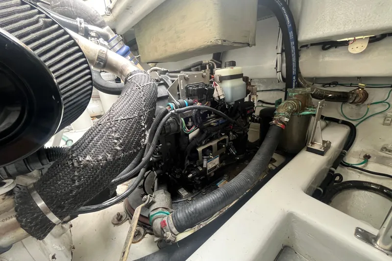 Slide: The Image of Engine room of 2010 Mikelson 43 Sportfisher with visible components and hoses. - 52