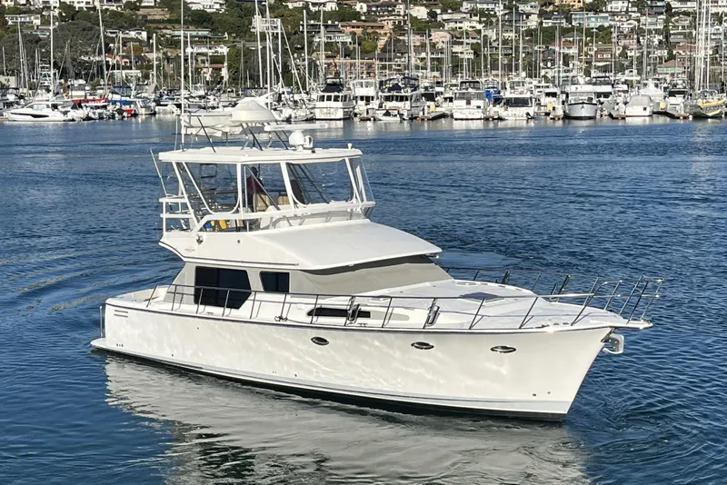 Slide: The Image of 2010 Mikelson 43 Sportfisher yacht cruising in a marina with docked boats. - 54