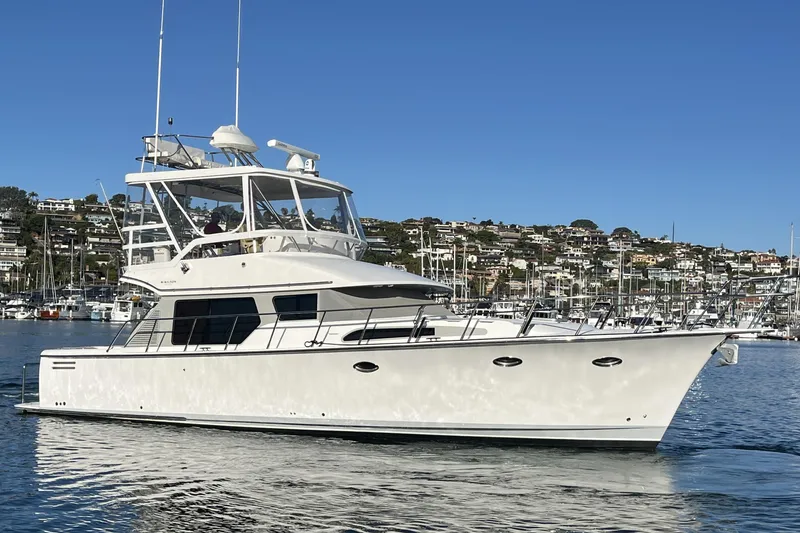 Slide: The Image of 2010 Mikelson 43 Sportfisher yacht on calm water, with coastal backdrop. - 55