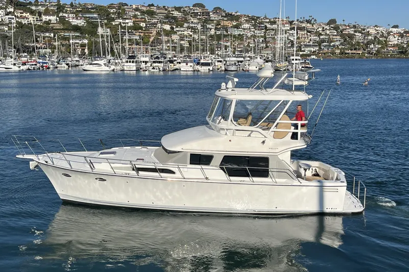 Slide: The Image of 2010 Mikelson 43 Sportfisher yacht cruising in a marina with scenic background. - 57