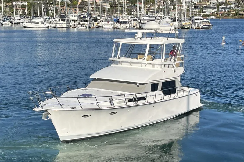 Slide: The Image of 2010 Mikelson 43 Sportfisher yacht cruising in a marina with sailboats in the background. - 59