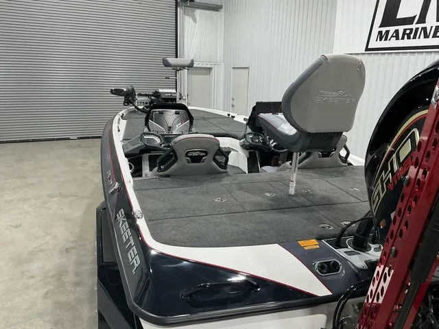 Slide: The Image of 2022 Skeeter FXR21 Apex fishing boat in a garage, showcasing seating and equipment. - 18