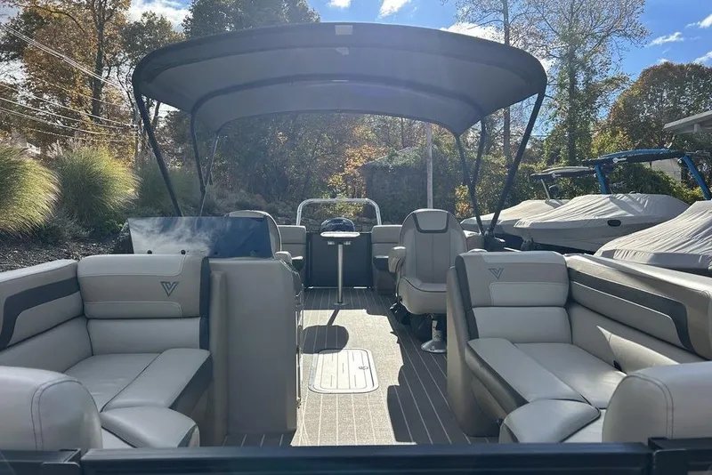 Slide: The Image of 2023 Viaggio L22U pontoon boat interior with seating and canopy, set in a sunny outdoor location. - 9