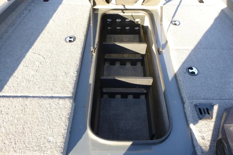 Slide: The Image of 2022 Ranger RT188P boat storage compartment with rod holders and carpeted interior. - 10