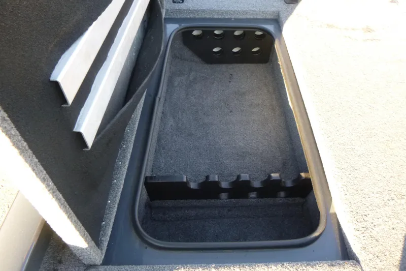 Slide: The Image of 2022 Ranger RT188P boat storage compartment with rod holders and carpeted interior. - 11